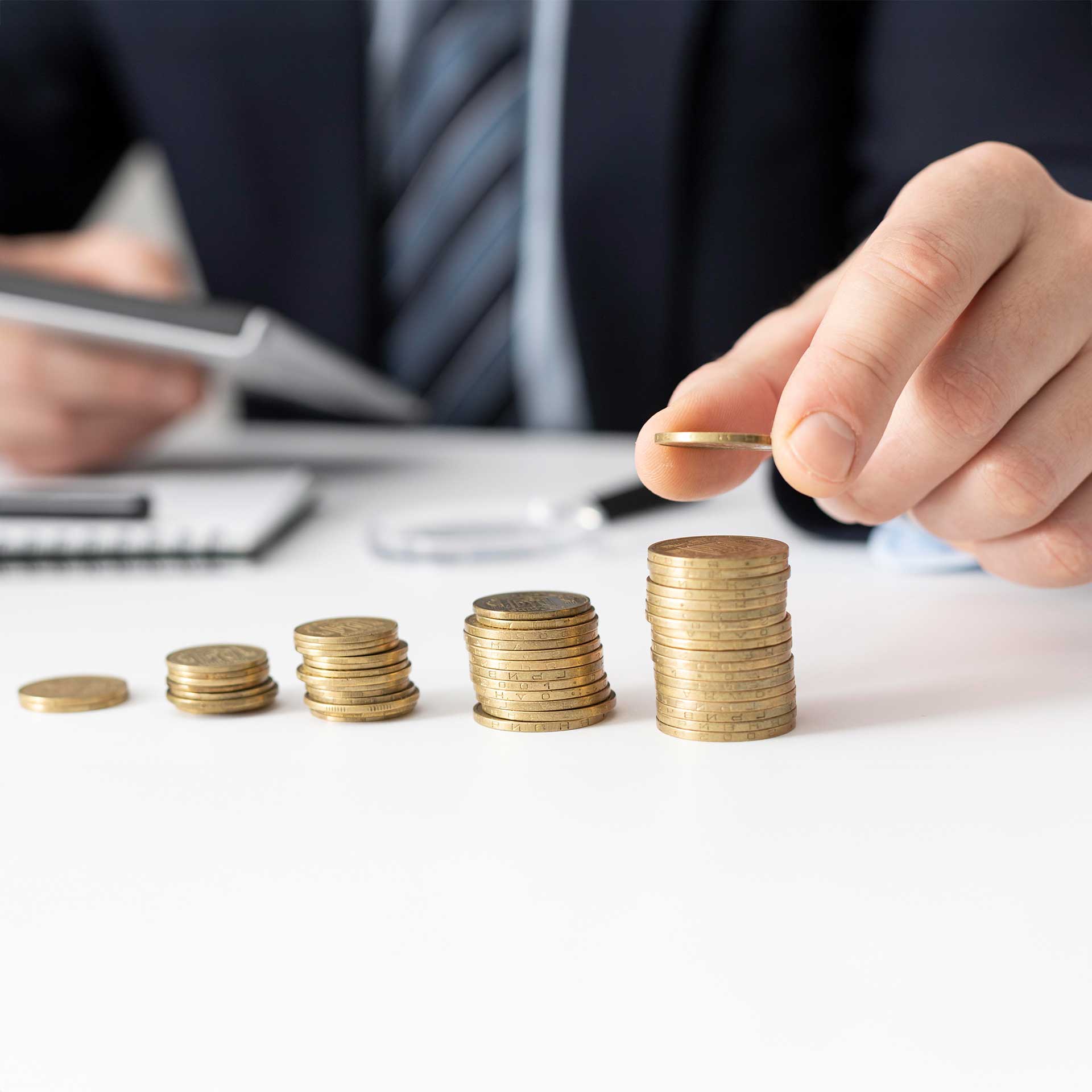 Ein Mann stapelt Münzen zu Türmen